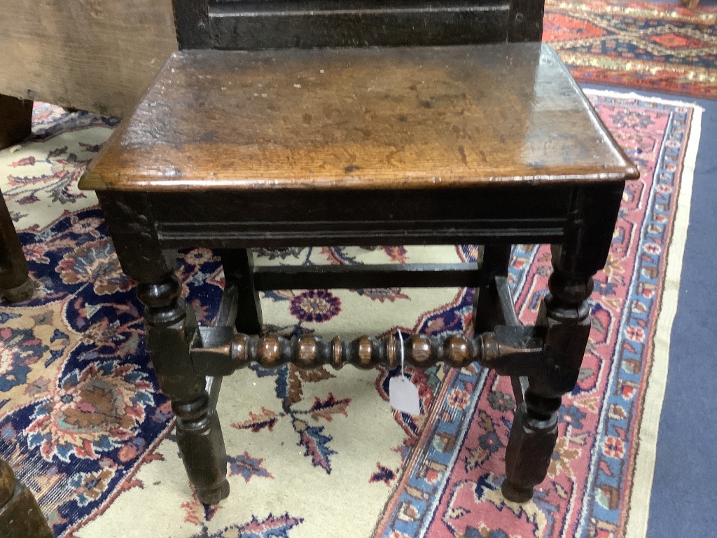 A 17th century oak back stool with bobbin front stretcher, width 47cm, depth 38cm, height 96cm